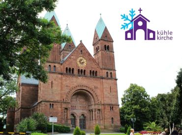 Die Erlöserkirche in Bad Homburg, umgeben von Bäumen. Im Bild das Logo „kühle ki
